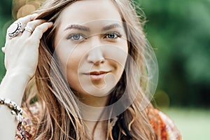 Portrait of Beautiful young woman wearing bohostyle clothes posing in the rays of the evening sun, sunset. Boho style