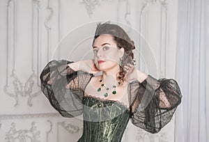 Portrait of Beautiful young woman wearing green medieval vintage Victorian Style dress