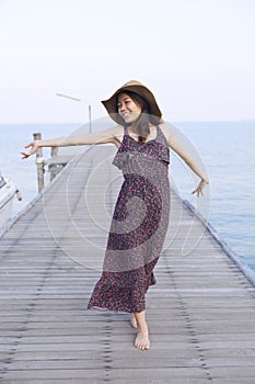 Portrait of beautiful young woman wearing wide straw hat and lon