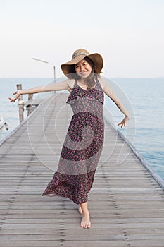 Portrait of beautiful young woman wearing wide straw hat and lon