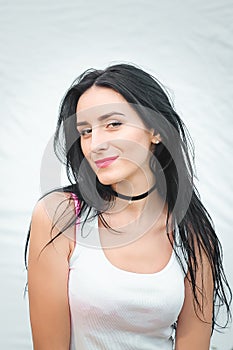 Portrait of a beautiful young woman in a white T-shirt with black hair. joy and laughter degenerate. positive emotions. Life style