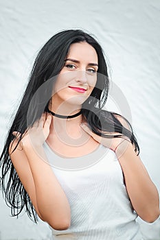 Portrait of a beautiful young woman in a white T-shirt with black hair. joy and laughter degenerate. positive emotions. Life style