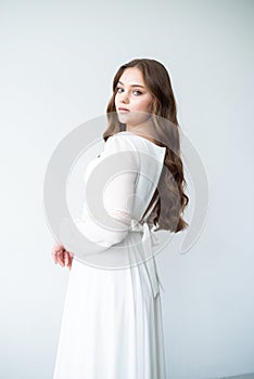 portrait of beautiful young woman in white wedding dress posing in studio.