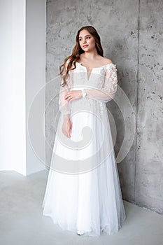 portrait of beautiful young woman in white wedding dress posing in studio.