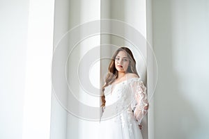 portrait of beautiful young woman in white wedding dress posing in studio.