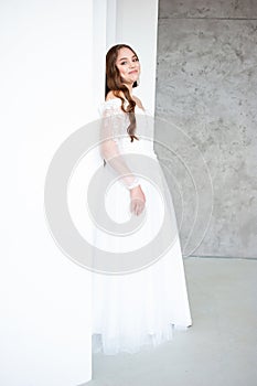 portrait of beautiful young woman in white wedding dress posing in studio.