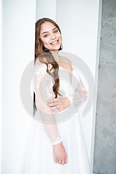 portrait of beautiful young woman in white wedding dress posing in studio.