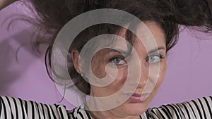 Portrait of a beautiful young woman who is looking at the camera funny, shaking her head and hair. Static emotions of a
