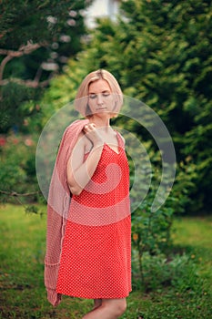 Portrait of beautiful young woman in wide beach hat, against background of summer green park