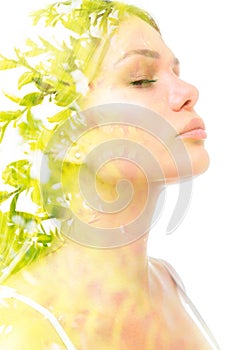 A double exposure portrait of a beautiful woman& x27;s profile with her eyes closed combined with a photo of green foliage