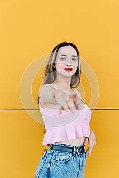 Portrait of a beautiful young woman on a yellow background