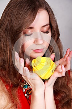 Portrait of a beautiful young woman with a yellow rose