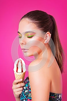 Portrait of beautifull woman with ice cream on a pink background.