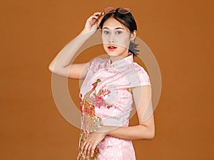 Portrait beauty action millennial Asian female model in pink cheongsam qipao traditional festival peacock and flowers pattern