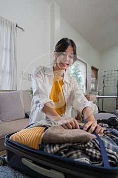 Portrait of beauty asian traveler woman pack prepare stuff and outfit clothes in suitcase travel bag luggage for summer