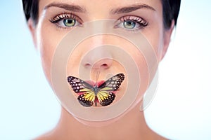 Portrait, beauty and butterfly with natural woman in studio on blue background for skincare or wellness. Spa, face or