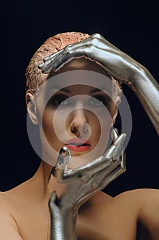 Portrait of beauty cyber woman from the future with clay hairstyle and silver hands