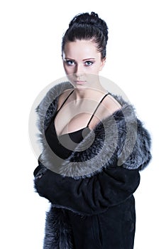 Beautiful brunette with decollete in luxury black color fur coat photo