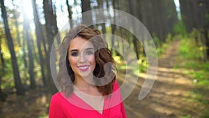 Portrait of Beauty Girl in red dress with Healthy Long Hair in forest. Happy woman smilling and laughing in Autumn in