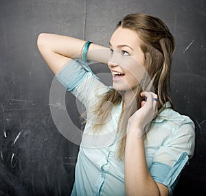 Portrait of beauty happy student with books near blackboard