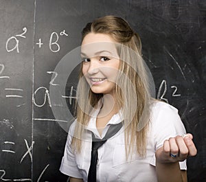 Portrait of beauty happy student with books near blackboard