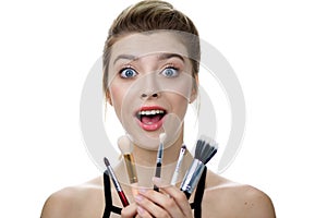 Portrait of beauty model with makeup and long eyelashes with cosmetic brush set in hand