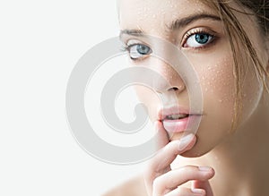 Beautiful young woman with clean perfect skin and water moisture drops touching face