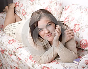 Portrait of beauty smiling woman with book reading on sofa