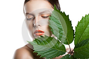 Portrait beauty woman face. Beautiful model Girl with Perfect Fresh Clean Skin. Girl with green leaves.