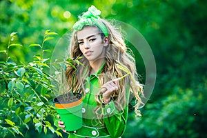 Portrait of beauty woman while working in garden. Beauty spring girl with flower pot. Springtime.