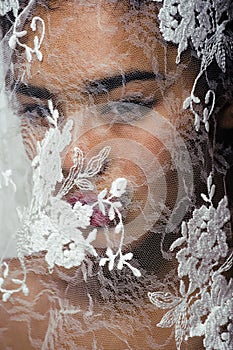 Portrait of beauty young afro woman through white lace, like new bride under veil close up