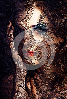 portrait of beauty young woman through lace close up mistery mak