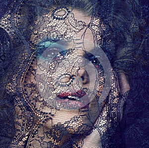 Portrait of beauty young woman through lace close up mistery makeup sexy, fashion people concept