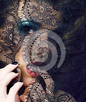 Portrait of beauty young woman through lace close up mistery makeup sexy, fashion people concept