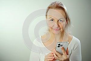 portrait of beautyful woman on the phone looks in camera Happy checking social media holding smartphone at home woman