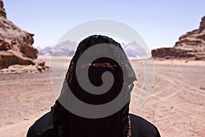 Portrait of Bedouin woman with burka in desert photo