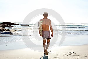 Portrait from behind of surfer walking to the ocean