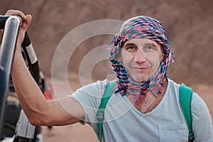 Portrait of a benevolent smiling man in an arabic headscarf