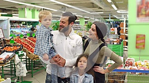 Portrait of a big happy family with two children in the supermarket.
