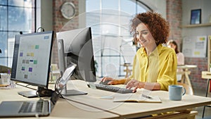 Portrait of Biracial Creative Young Woman Working on a Computer in Bright Busy Office. Female