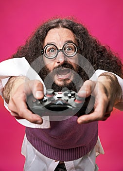 Portrait of a bizarre nerd holding a gamepad