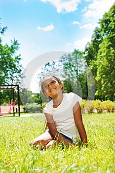 Portrait of black girl in park dreaming on lawn