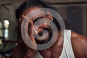 portrait of a black male athlete with a pierced ear who smiles