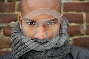 Portrait of a black male fashion model with gray scarf covering face