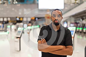 Portrait of black man ready to travel at airport terminal waiting for flight