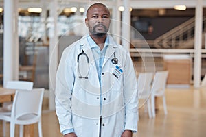 Portrait, black man and serious doctor in hospital for healthcare. African medical professional, face and surgeon