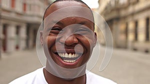 Portrait of black man very happy, smiling in urban background. An african american student sincerely smiles while