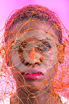 Portrait of a black short haired woman with an orange net over her head