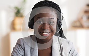 Portrait of black smiling female call center operator in headset