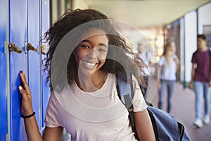 Portrait of black teenage girl by lockers in school corridor